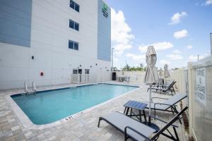 坦帕Holiday Inn Express & Suites Tampa Stadium - Airport Area, an IHG Hotel的大楼前的游泳池