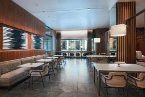 休斯顿AC Hotel by Marriott Houston Downtown的餐厅设有桌椅和窗户。