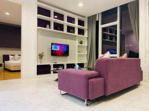 吉隆坡The Platinum Suites KLCC By World Luxury的客厅配有紫色沙发和电视