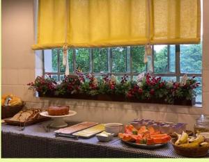 布卢梅瑙Pousada da Alê的一张桌子,上面有食物,有窗户