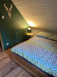 下乌斯奇基Domki że Hej Bieszczady的一间卧室设有一张床和绿色的墙壁