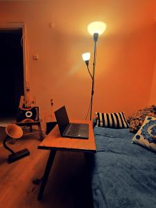 伊兹密尔ZULA HOUSE的配有一张床铺的房间,桌子上摆放着一台笔记本电脑