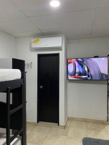 巴耶杜帕尔Mami Yola的一间设有黑色门的房间和墙上的电视