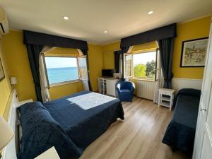 圣塔马利奈拉伊索拉酒店的一间带一张床和两个窗户的卧室,享有海景