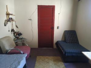卡瓦坎特Casa Aloe Vera的一间设有红色门、一张床和椅子的房间