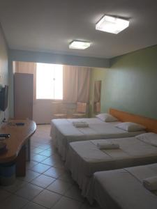 福塔莱萨博里斯公寓酒店 的酒店客房设有三张床和窗户。