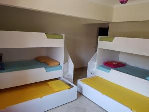 艾因苏赫纳Telal Ground Floor 2 bedroms的客房设有两张双层床,配有不同的彩色床单