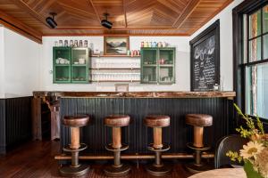 TannersvilleHotel Mountain Brook的酒吧设有木制天花板和木凳