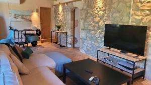 锡内乌Borgata Roggio的带沙发和平面电视的客厅