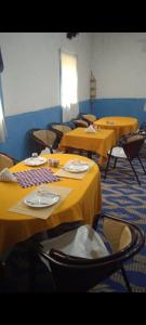 KhamliyaCafe Restaurant Etto的一间房间,配有几张桌子和黄色桌布
