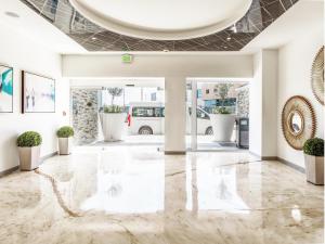 华雷斯城Hotel Mesaluna Short & Long Stay的大堂设有大理石地板和盆栽植物