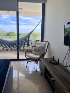 圣卡洛斯Acogedor apartamento de playa en Casamar para 4的一间带椅子和电视的客厅以及一个阳台。