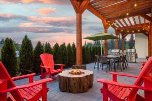 亨茨维尔Home2 Suites By Hilton Huntsville的庭院设有红色的椅子和一张带火坑的桌子。