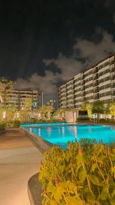 Ban Khlong Samrongsupalai city resort的夜间蓝色海水的大型游泳池