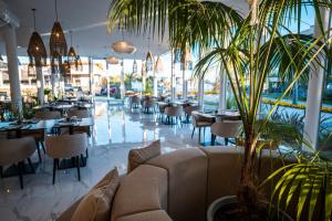 埃斯特角城SYRAH Premium B2 - Vistas al Parque by depptö的一间设有桌椅的餐厅,并种植了棕榈树
