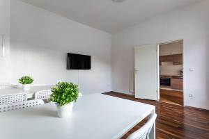 杜伊斯堡T&K Apartments - Duisburg - 3 and 4 Room Monteur Apartments的白色的客房设有白色的桌子和两盆植物