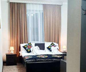 奥什Ocean hotel的卧室配有带枕头的床铺和窗户。