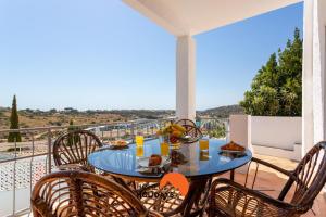 阿尔布费拉#185 Private Marina and Ocean View with Pool的阳台上配有一张蓝色桌子、椅子和食物