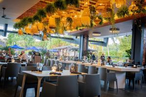 帕拉马里博Torarica Resort的一间带桌椅的餐厅和一间酒吧