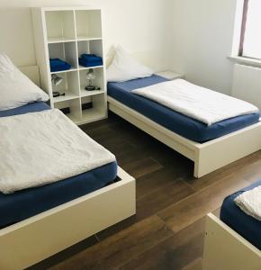 ImsumHOSTEL 66 Bremerhaven Geestland的铺有木地板的客房内的两张床