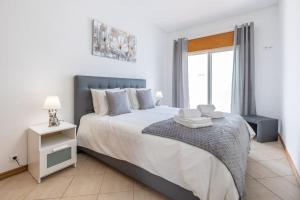 奎特里拉Sea-Front near Vilamoura - with AC, WiFi, Netflix的一间卧室设有一张大床和一个窗户。