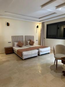 马拉喀什Villa Novia的一间卧室配有两张床和椅子