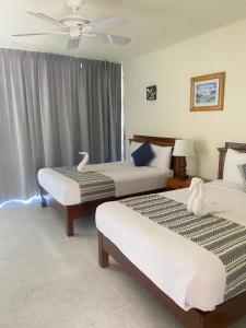 锡瓦塔塔内霍Hotel Villas Ema的酒店客房配有两张床和吊扇。
