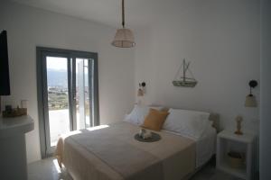 KrotiriKrotiri View Paros的白色的卧室设有床和大窗户