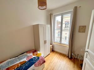 贡比涅Appartement entier en plein coeur du centre ville的一间卧室设有一张床和一个大窗户