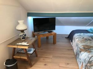 BeilenAltynghe的一间卧室配有一张床和一张桌子及一台电视