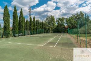 锡耶纳Villa Le Tortore privata lusso piscina relax Siena的一座带树木和围栏的网球场