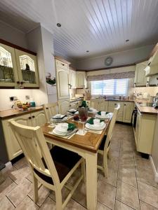 GreencastleThe Myles' Self-Catering Cottage - 4 Stars的厨房配有木桌和椅子