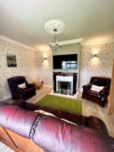 GreencastleThe Myles' Self-Catering Cottage - 4 Stars的带沙发和壁炉的客厅