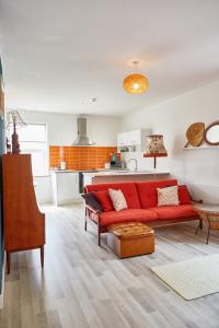 克利索普斯Binks - Seafront 1 bed first floor apartment的一间带红色沙发的客厅和一间厨房