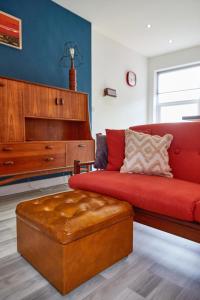 克利索普斯Binks - Seafront 1 bed first floor apartment的客厅配有红色沙发和钢琴
