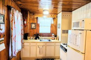 温泉城#08 - One Bedroom Lakeview Cottage-Pet Friendly的厨房配有白色冰箱和水槽