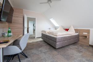 Breitscheid蓝哥祖尔荣酒店 的卧室配有一张床和一张桌子及椅子