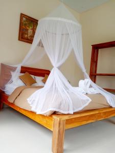 德格拉朗Ubud nadi villa的卧室配有带白色蚊帐的床