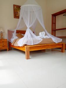 德格拉朗Ubud nadi villa的一间卧室配有一张带蚊帐的床