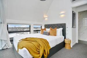 基督城Latimer Loft - Christchurch Holiday Homes的一间卧室设有一张大床和大窗户