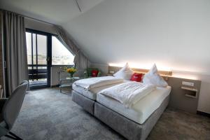 Breitscheid蓝哥祖尔荣酒店 的酒店客房设有一张床和一个大窗户