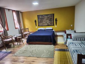 欧鲁普雷图Solar dos Reis Apartamento Topázio的一间卧室设有两张床和黄色的墙壁