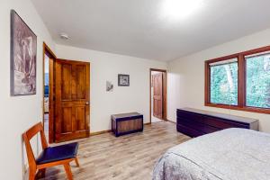 安克雷奇Raspberry Retreat的卧室配有床、椅子和窗户。