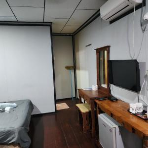 Kampong Juara刁曼佩买小木屋的客房设有一张桌子、一台电视和一张桌子