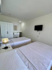 赫尔格达Serafy City Center Hostel and Pool for Foreigners Adults Only的一间卧室配有两张床和一台平面电视