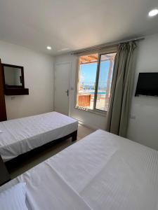 赫尔格达Serafy City Center Hostel and Pool for Foreigners Adults Only的一间卧室设有两张床和一个美景窗户。