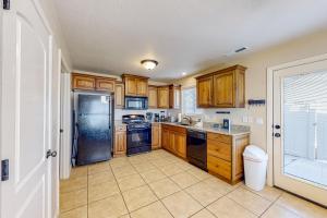 雪松城Cedar Park Oasis的厨房配有木制橱柜和不锈钢冰箱。