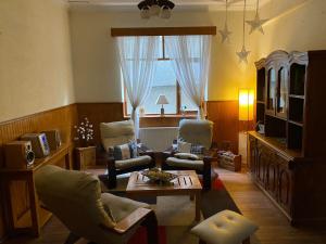 蓬塔阿雷纳斯CHALET CHAPITAL Punta Arenas的客厅配有椅子、桌子和窗户