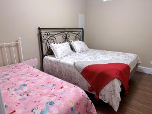 温哥华Hudson House的一间卧室配有两张床和一张带床罩的床。