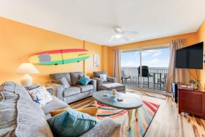 奥蒙德海滩Updated Oceanfront Condo! Come Relax by the Sea!的客厅配有沙发和冲浪板。
